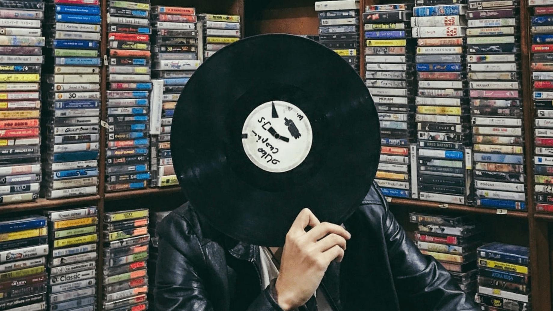 Vinyl held by a person to hide their face in a CD/vinyl store