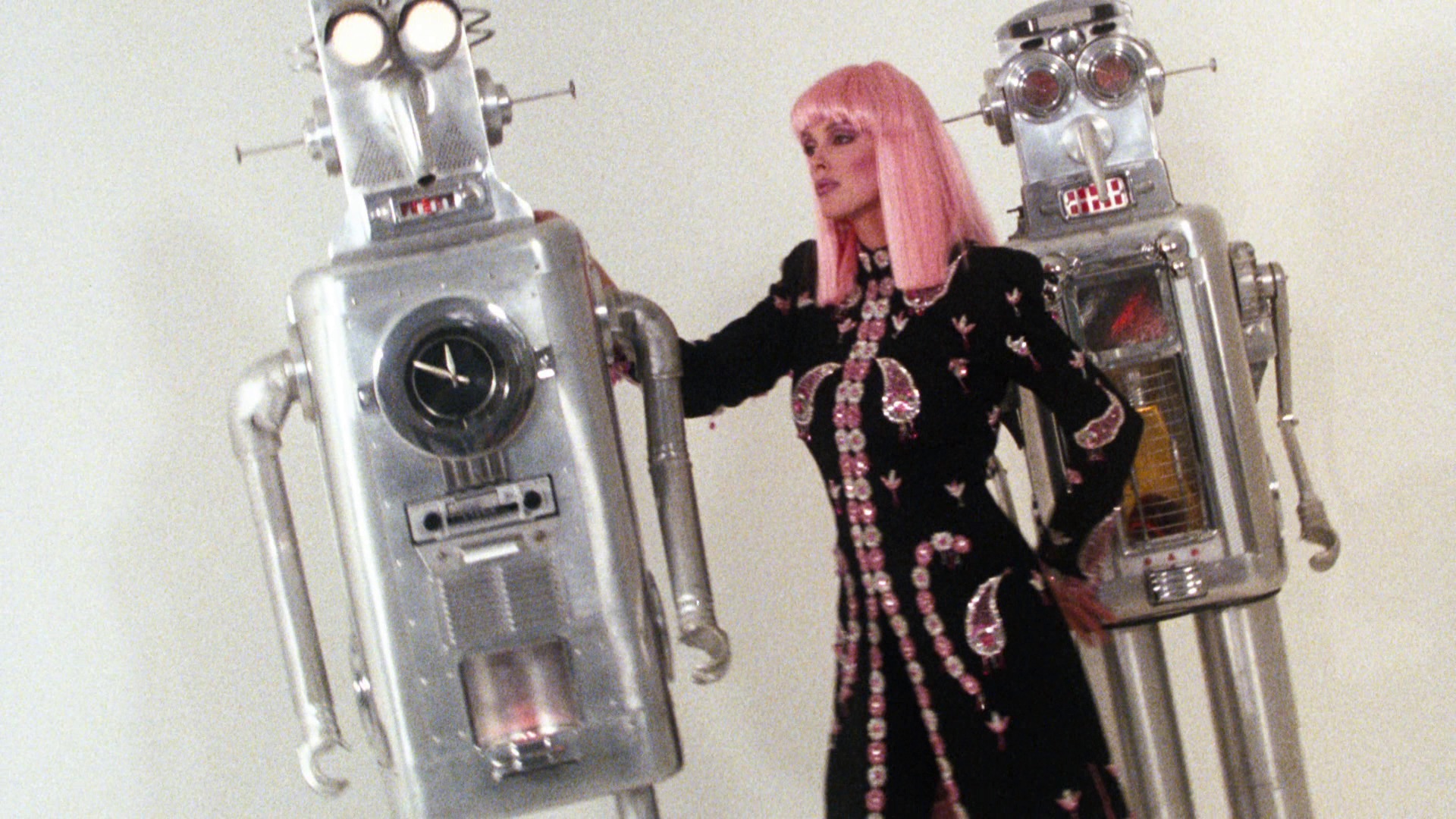 Vintage film photo of a woman with pink hair dancing with robots 