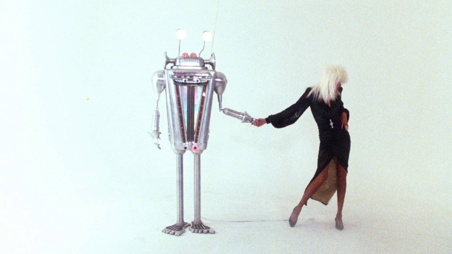 Vintage film photo of a woman with white hair dancing with robots 